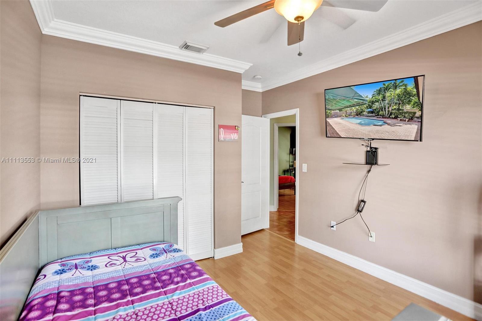 15816 Southwest 103rd Lane Miami, FL 33196 - Photo 28 of 49 a bedroom with a bed and a chandelier