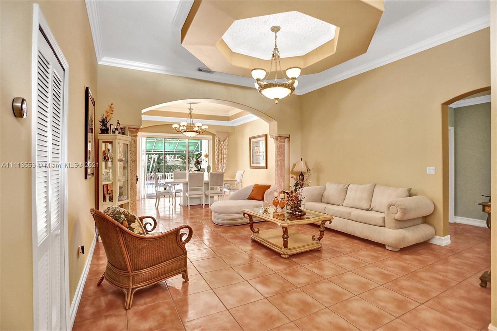 15816 Southwest 103rd Lane Miami, FL 33196 - Photo 4 of 49 a living room with furniture a chandelier and a large window
