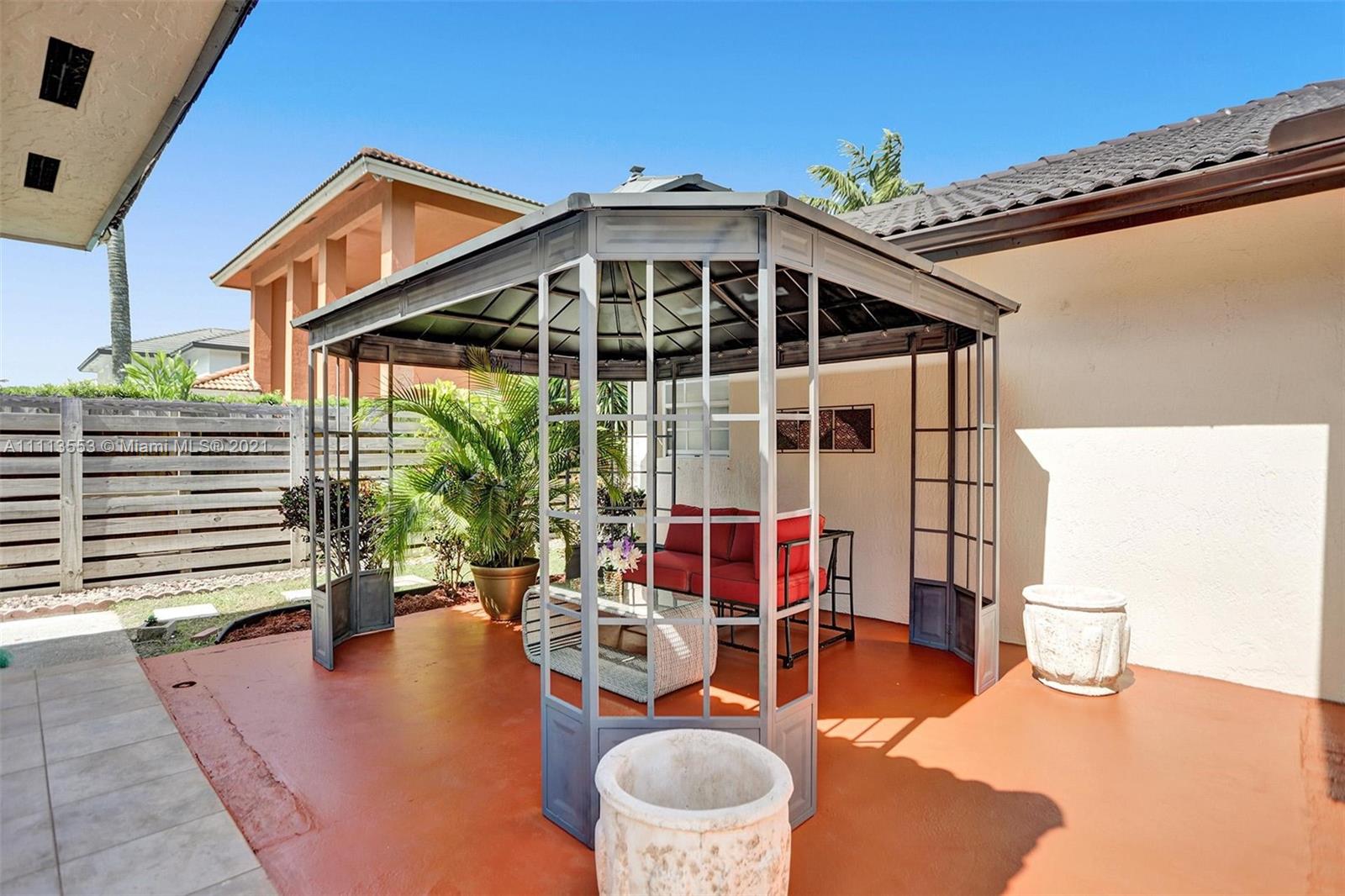 15816 Southwest 103rd Lane Miami, FL 33196 - Photo 42 of 49 a view of a patio with couches table and chairs and potted plants