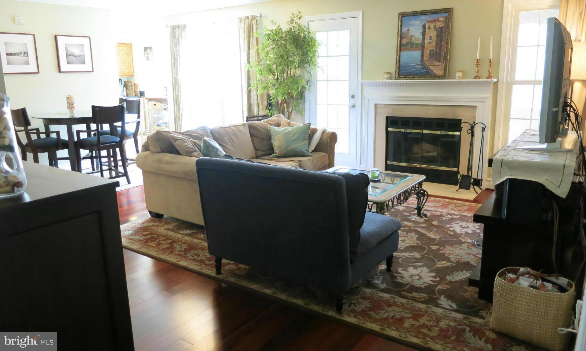 1423 Church Hill Place, Unit 1423 Reston, VA 20194 - Photo 4 of 26 a living room with furniture wooden floor and a fireplace