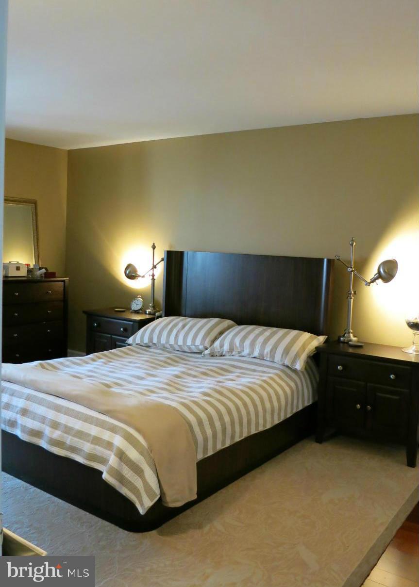 1423 Church Hill Place, Unit 1423 Reston, VA 20194 - Photo 8 of 26 a bedroom with a bed and a lamp
