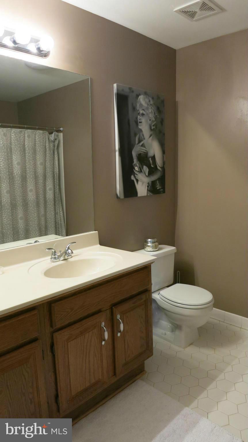 1423 Church Hill Place, Unit 1423 Reston, VA 20194 - Photo 10 of 26 a bathroom with a toilet a sink and mirror