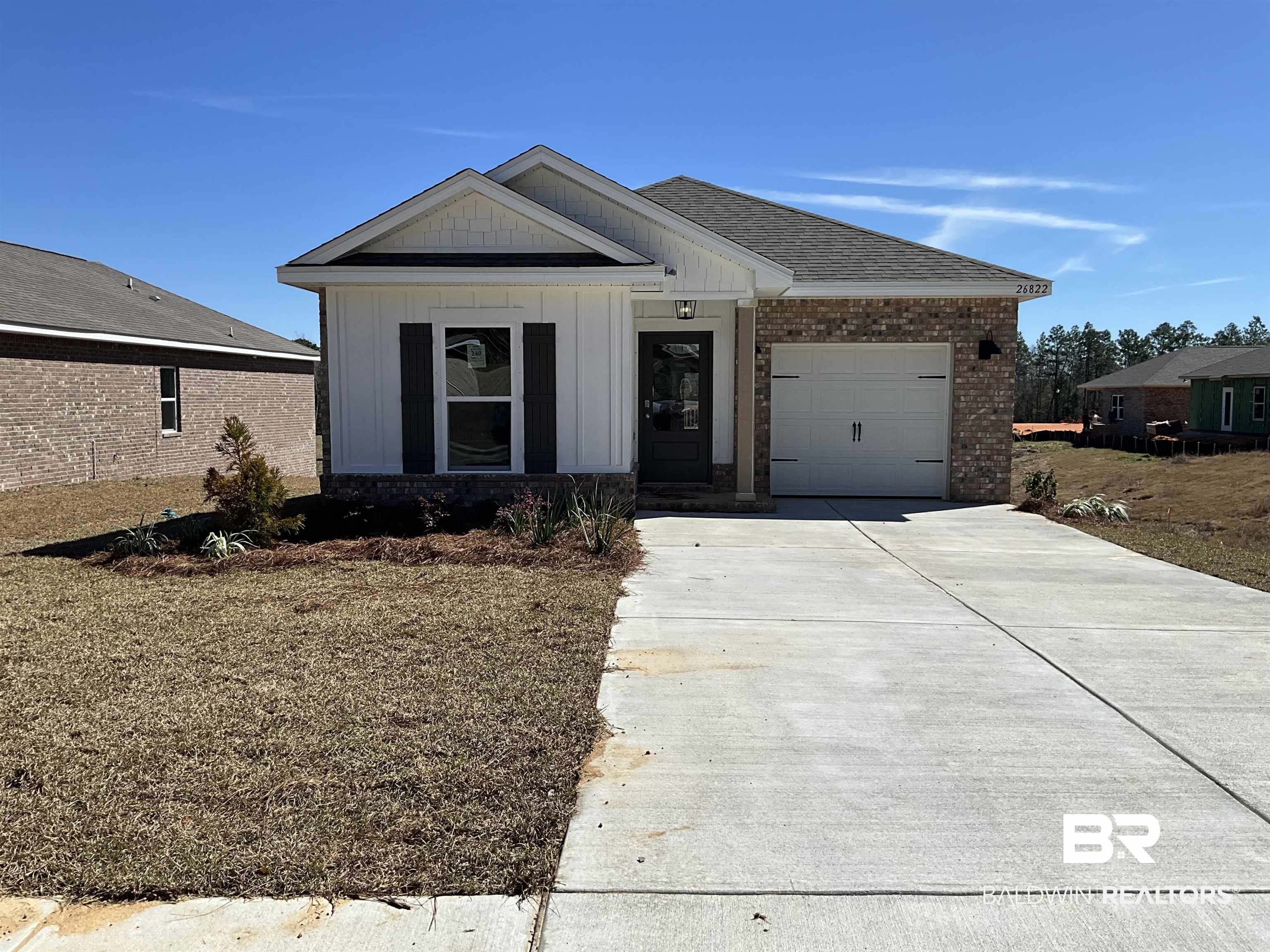 26822 Setai Court Daphne, AL 36526 - Photo 1 of 33 View of front facade featuring a garage, brick siding, a shingled roof, driveway, and board and batten siding