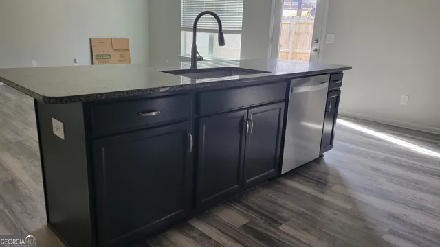a kitchen with granite countertop a sink and wooden floor