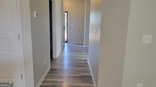 a view of a hallway with wooden floor