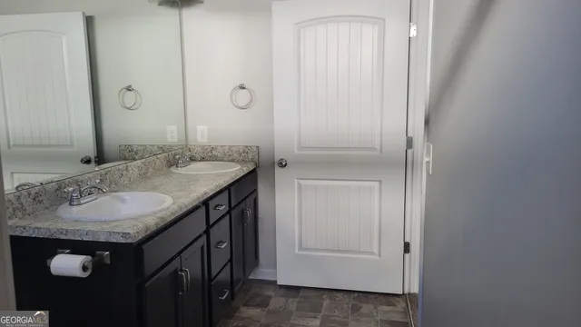 a bathroom with a granite countertop sink and a mirror