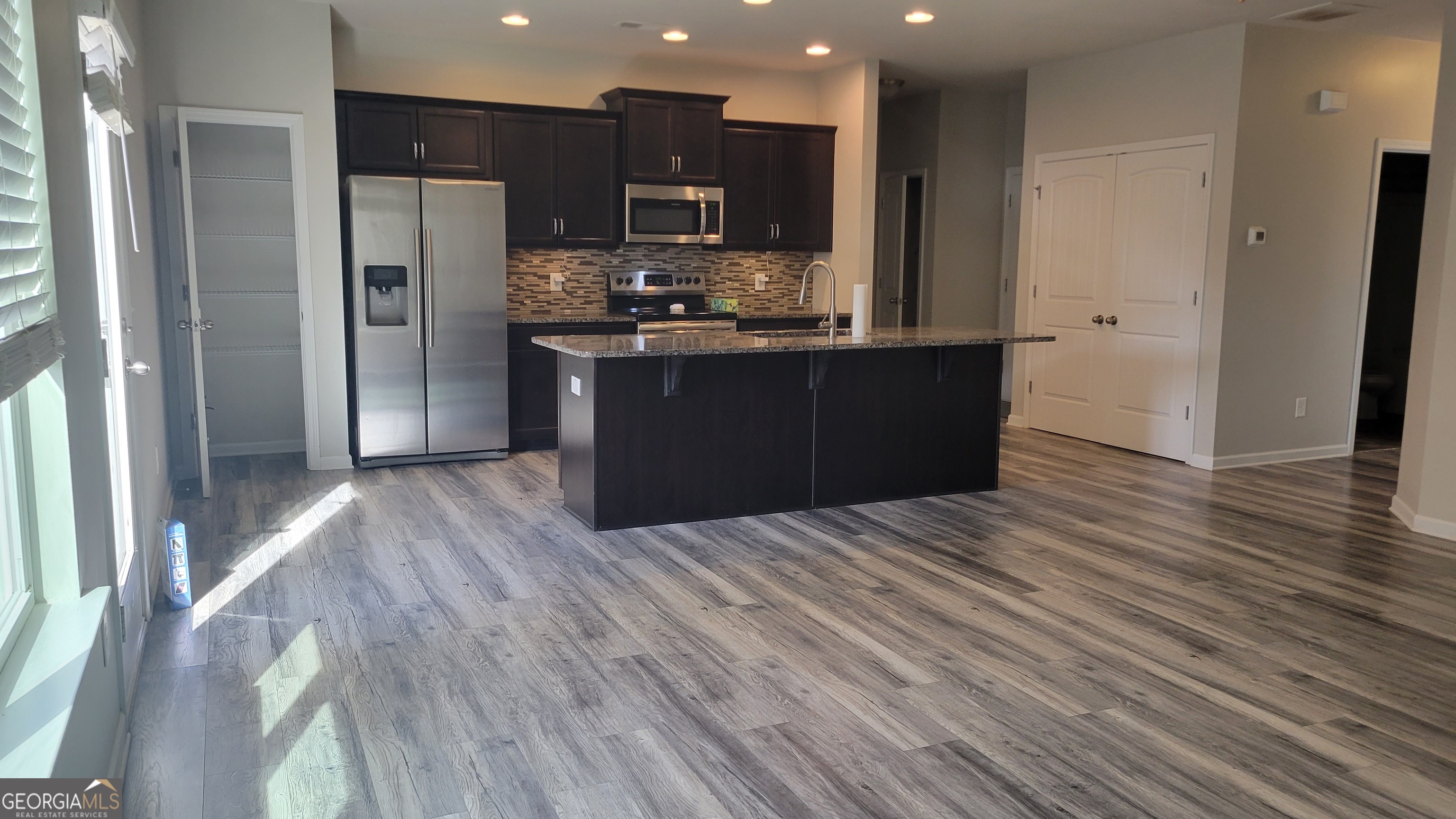 1 Berryrun Drive Rome, GA 30165 - Photo 8 of 23 a kitchen with stainless steel appliances kitchen island granite countertop wooden floors a refrigerator and a sink