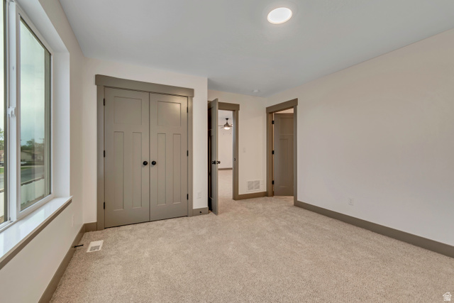 3317 South 1000 West, Unit 6010 Logan, UT 84321 - Photo 24 of 34 Unfurnished bedroom with light carpet and a closet