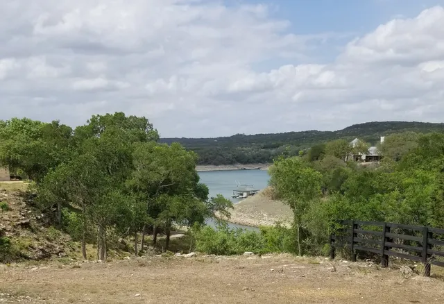 an aerial view of a house with a yard and mountain view in back