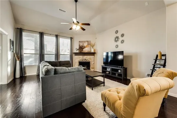 a living room with furniture a flat screen tv and a fireplace