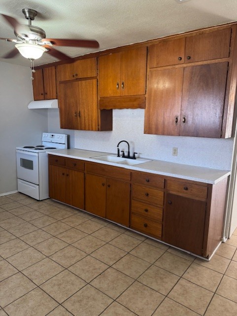 1802 West Avenue H, Unit A Temple, TX 76504 - Photo 3 of 6 Kitchen featuring white electric range, light countertops, brown cabinets, a textured ceiling, and a ceiling fan