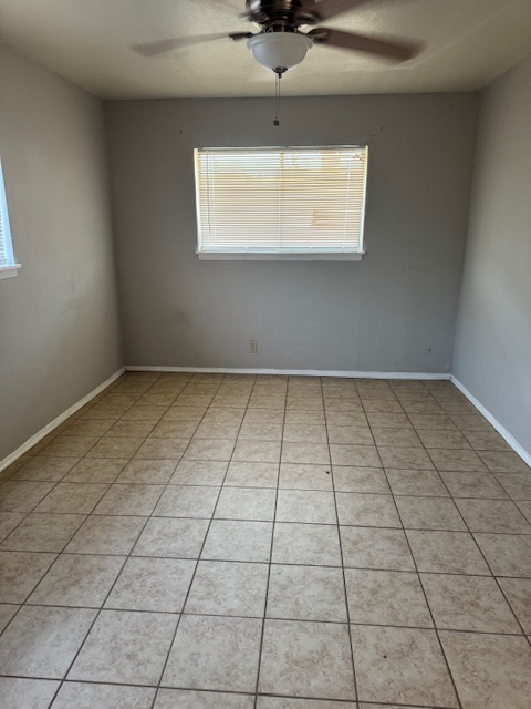 1802 West Avenue H, Unit A Temple, TX 76504 - Photo 4 of 6 Spare room featuring ceiling fan, light tile patterned floors, and healthy amount of natural light