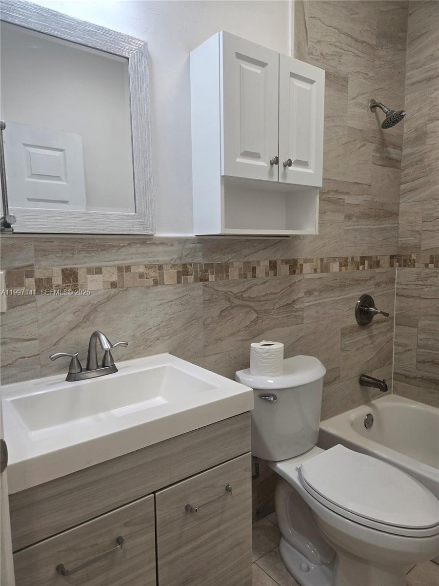 9740 Northwest 5th Avenue Miami, FL 33150 - Photo 15 of 18 a bathroom with a sink a toilet and mirror