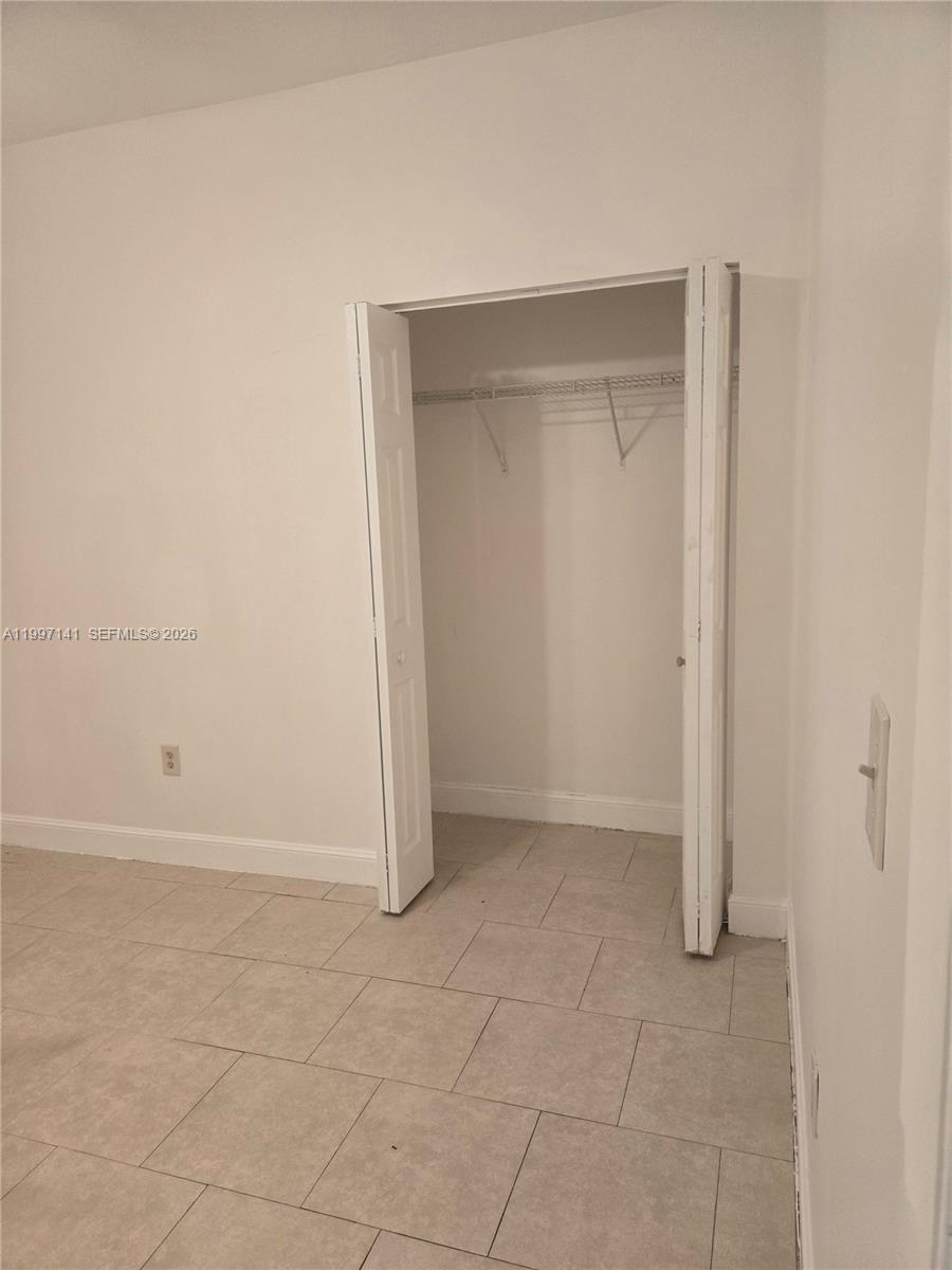 9740 Northwest 5th Avenue Miami, FL 33150 - Photo 8 of 18 an empty room with a bench