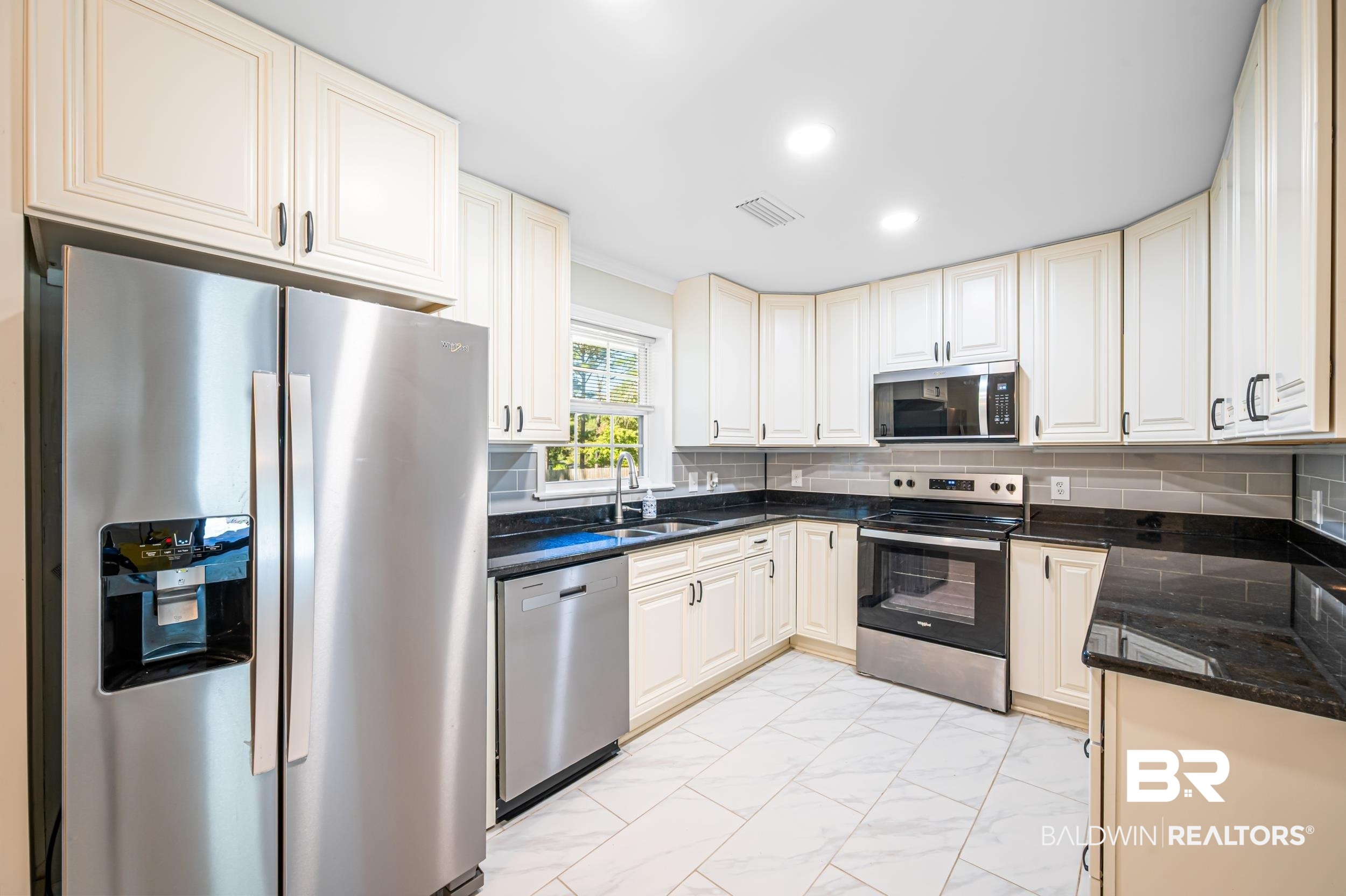 1605 Collier Avenue Bay Minette, AL 36507 - Photo 5 of 36 Kitchen featuring decorative backsplash, stainless steel appliances, light marble finish floors, recessed lighting, and dark stone counters