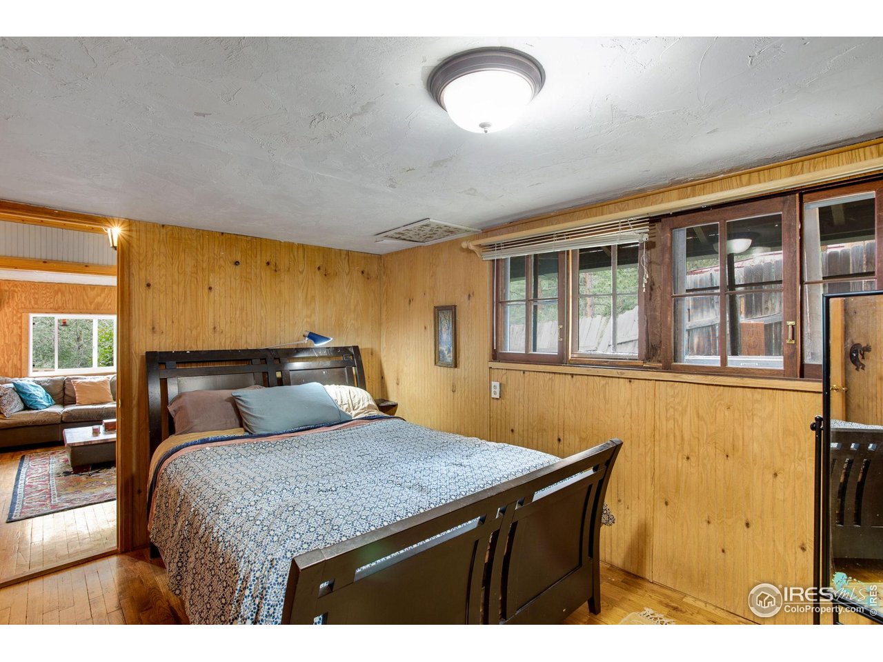 2248 Riverside Drive Lyons, CO 80540 - Photo 19 of 28 a bedroom with a bed and wooden floor