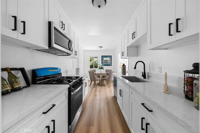 a kitchen with stainless steel appliances a sink a stove and cabinets