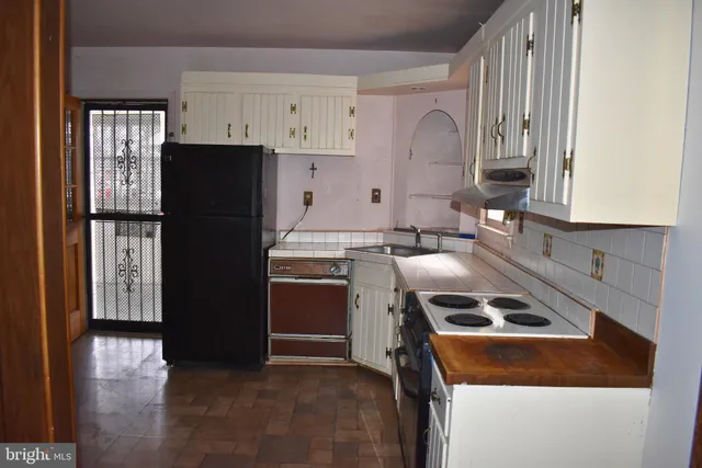 a kitchen with a refrigerator and a stove top oven