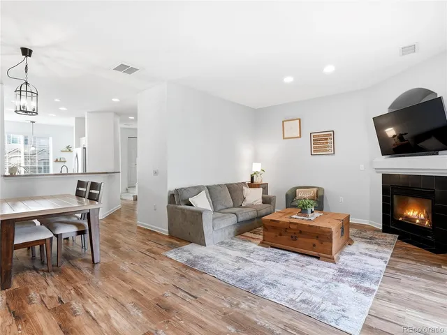 a living room with furniture a flat screen tv and a fireplace