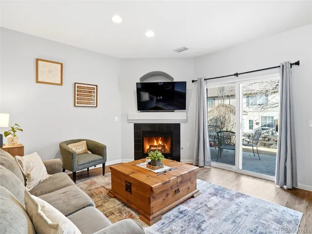 a living room with a fireplace and a potted plant