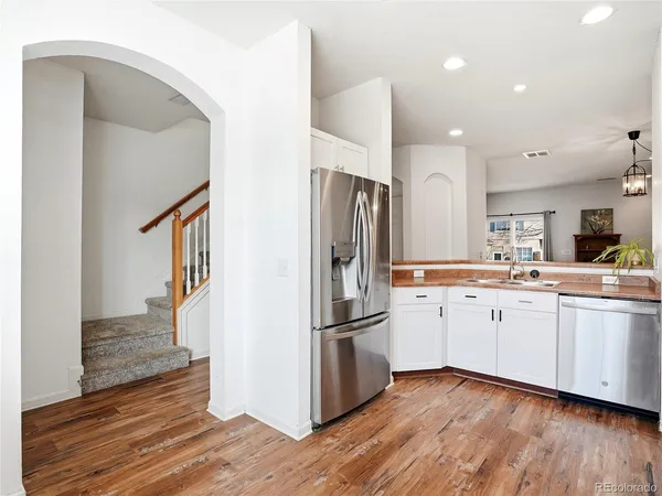 a kitchen with stainless steel appliances a refrigerator sink and wooden floor