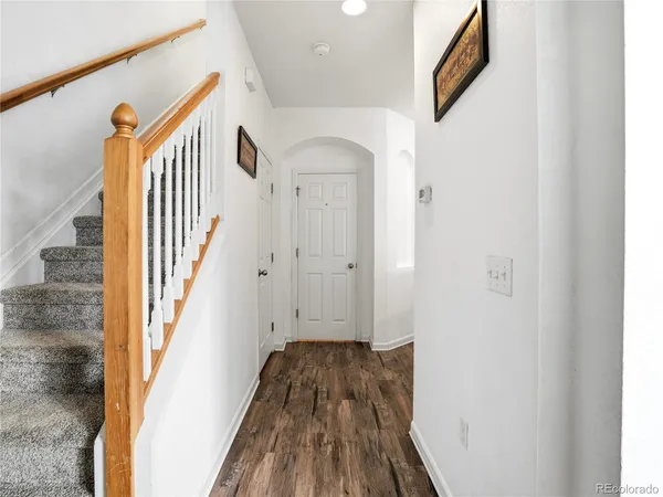 a view of a hallway with wooden floor and staircase