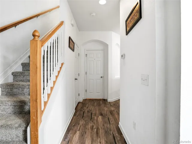 a view of a hallway with wooden floor and staircase