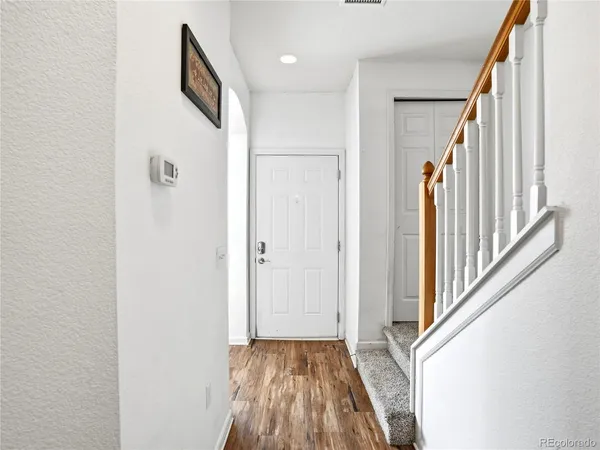 a view of a hallway with wooden floor and staircase
