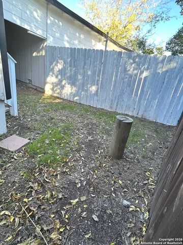 a view of a backyard with wooden fence