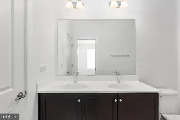 a kitchen with a sink a kitchen island stainless steel appliances cabinets and a wooden floor