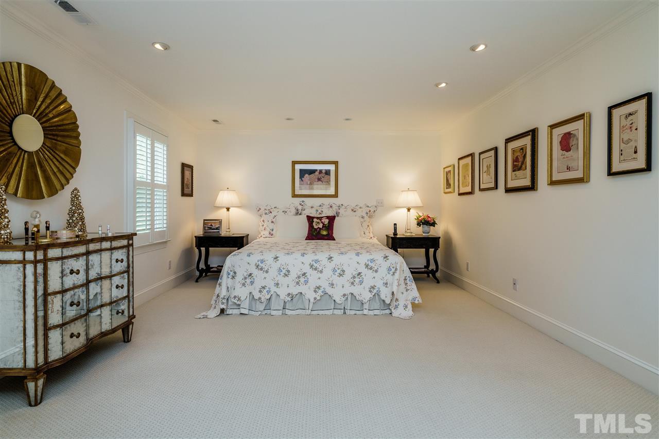 8509 Riddle Place Raleigh, NC 27615 - Photo 18 of 30 a bedroom with a bed a mirror on the dresser and entryway