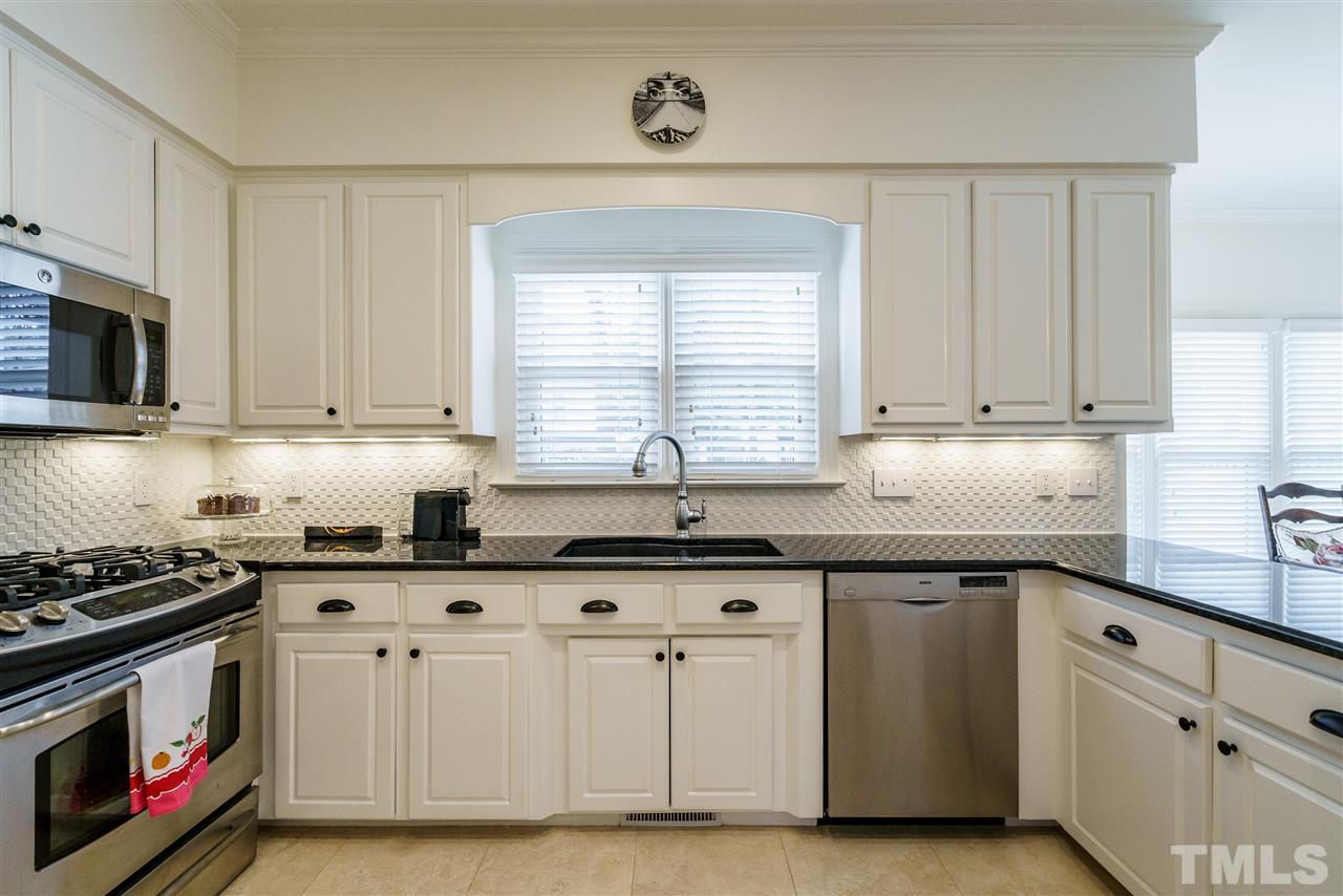 8509 Riddle Place Raleigh, NC 27615 - Photo 8 of 30 a kitchen with granite countertop white cabinets and white appliances