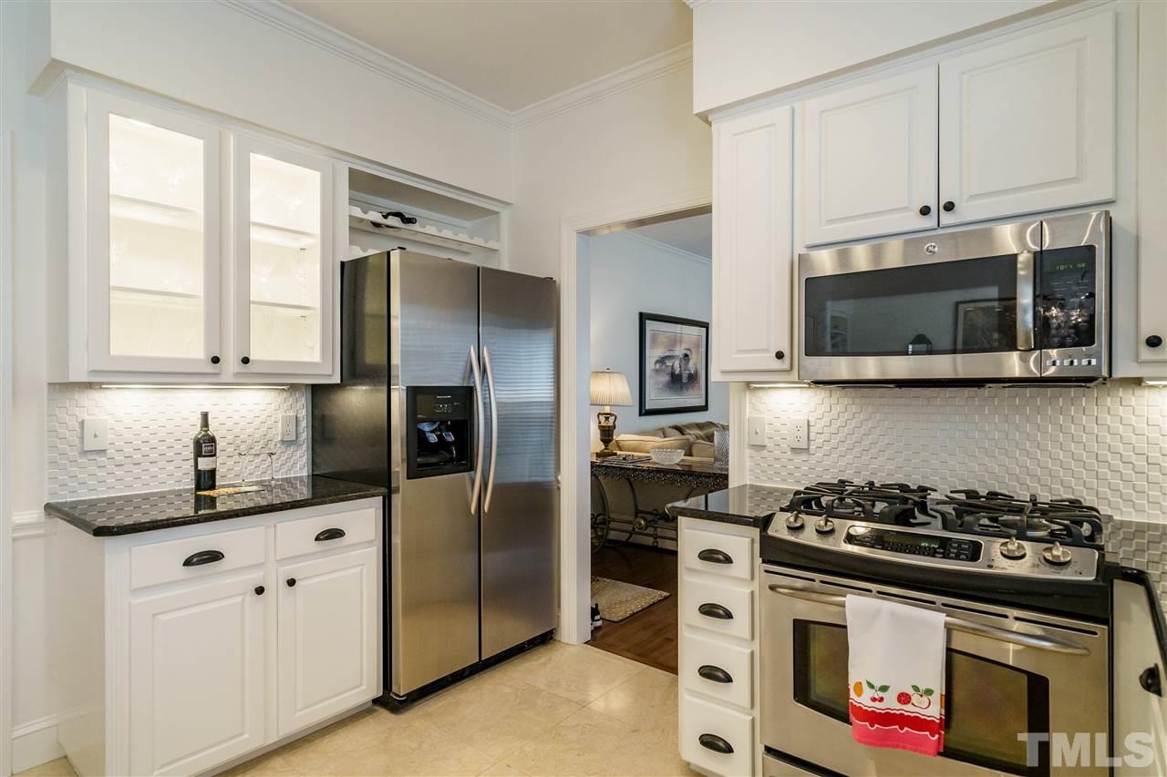 8509 Riddle Place Raleigh, NC 27615 - Photo 10 of 30 a kitchen with stainless steel appliances granite countertop a stove a refrigerator and a microwave