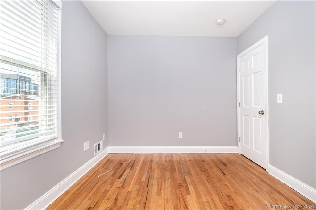 29 Dolsen Place, Unit 2 Stamford, CT 06901 - Photo 11 of 18 an empty room with wooden floor and windows