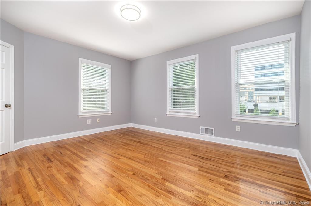 29 Dolsen Place, Unit 2 Stamford, CT 06901 - Photo 8 of 18 a view of an empty room with wooden floor and a window