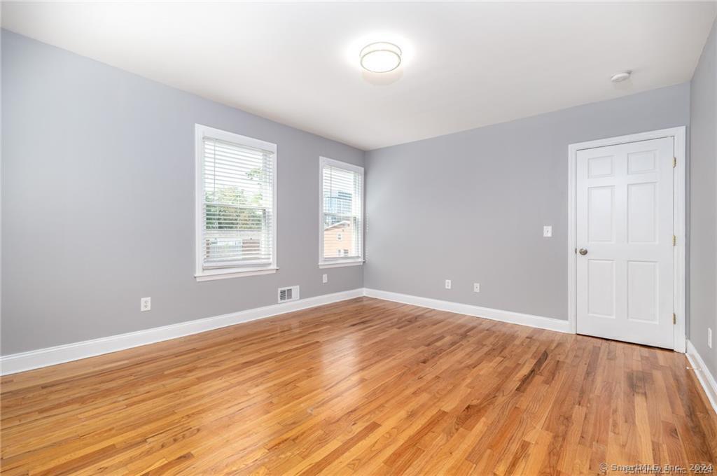 29 Dolsen Place, Unit 2 Stamford, CT 06901 - Photo 9 of 18 an empty room with wooden floor and windows