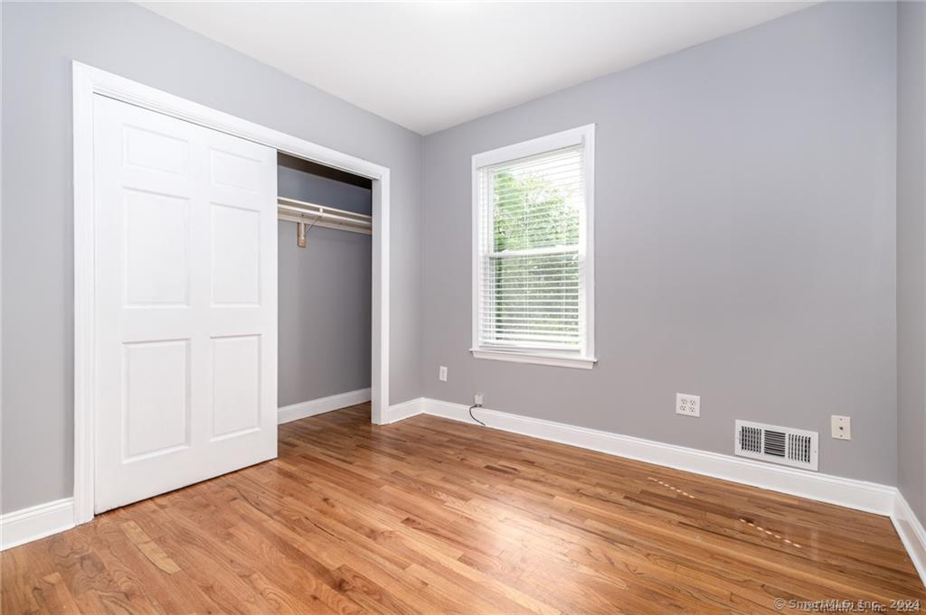 29 Dolsen Place, Unit 2 Stamford, CT 06901 - Photo 10 of 18 a view of an empty room with wooden floor and a window