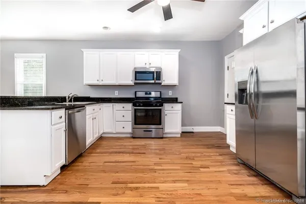 a kitchen with stainless steel appliances granite countertop a stove a sink and a refrigerator