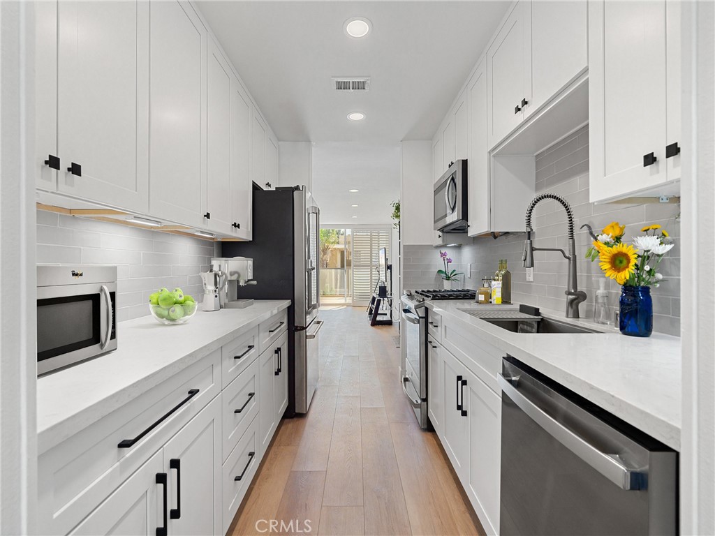 1 3rd Place, Unit 2 Long Beach, CA 90802 - Photo 4 of 40 a kitchen with kitchen island granite countertop counter space stainless steel appliances and cabinets