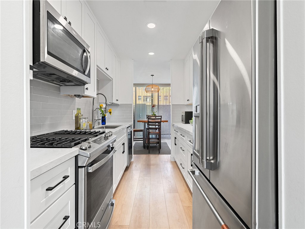 1 3rd Place, Unit 2 Long Beach, CA 90802 - Photo 5 of 40 a kitchen with stainless steel appliances granite countertop hardwood floor sink stove and refrigerator