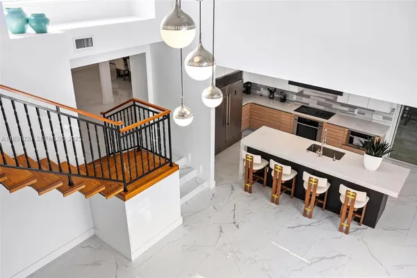 a kitchen with stainless steel appliances granite countertop a sink a stove and a refrigerator