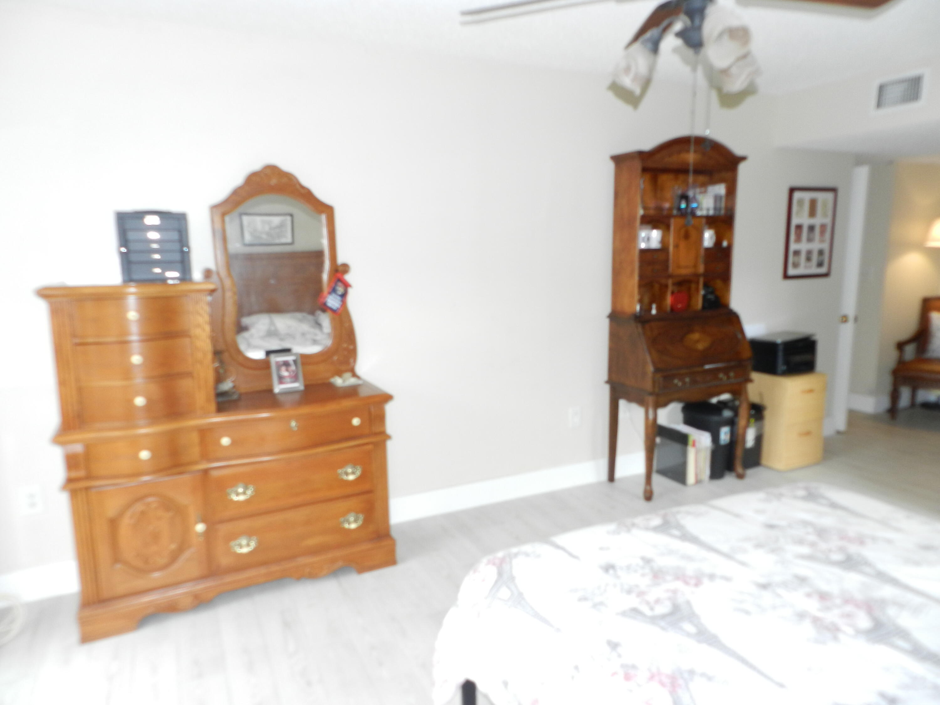 7 Greenway Village North, Unit 103 Royal Palm Beach, FL 33411 - Photo 19 of 29 a bedroom with a bed and wooden floor