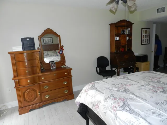 a bedroom with a bed window and a dresser