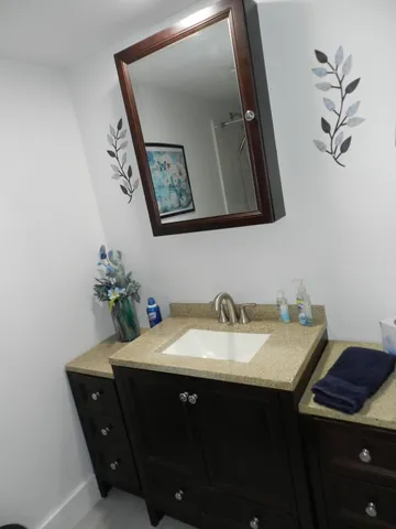 a bathroom with a granite countertop sink a mirror and vanity