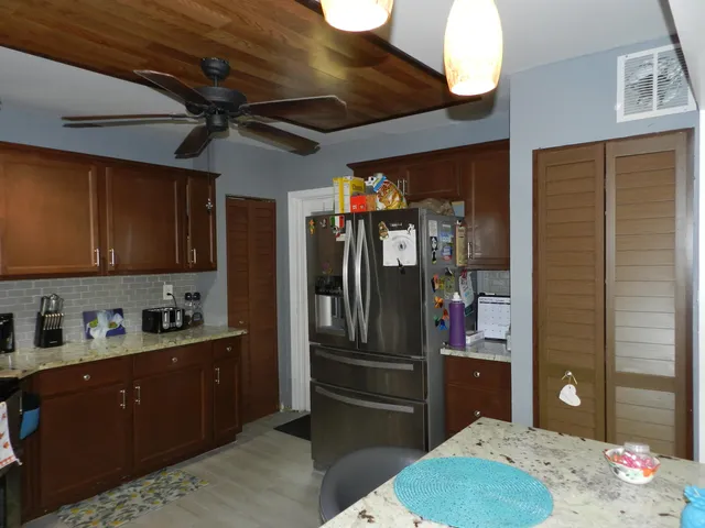 a kitchen with stainless steel appliances kitchen island granite countertop a refrigerator a sink and dishwasher