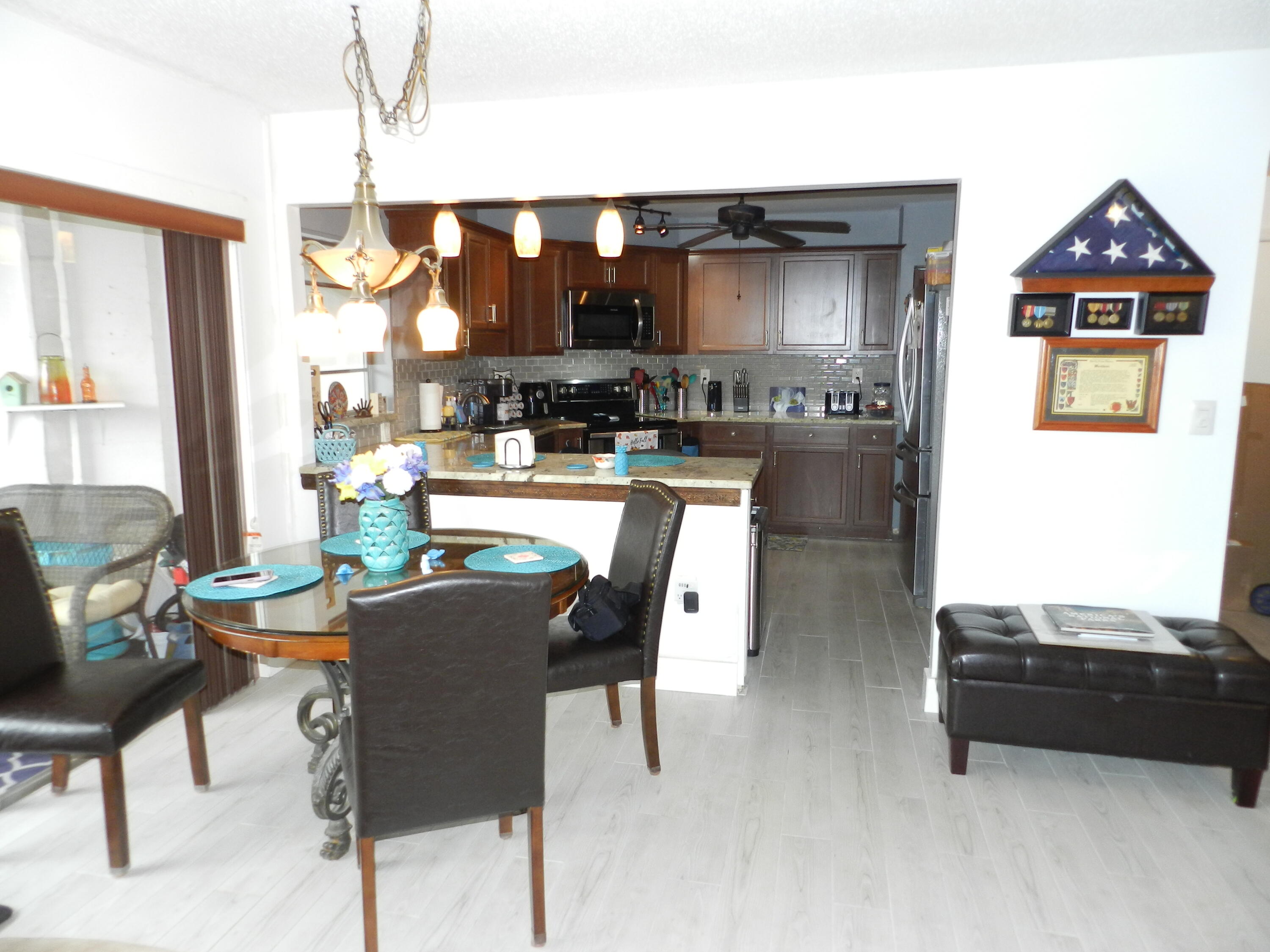 7 Greenway Village North, Unit 103 Royal Palm Beach, FL 33411 - Photo 6 of 29 a dining room with furniture and chandelier
