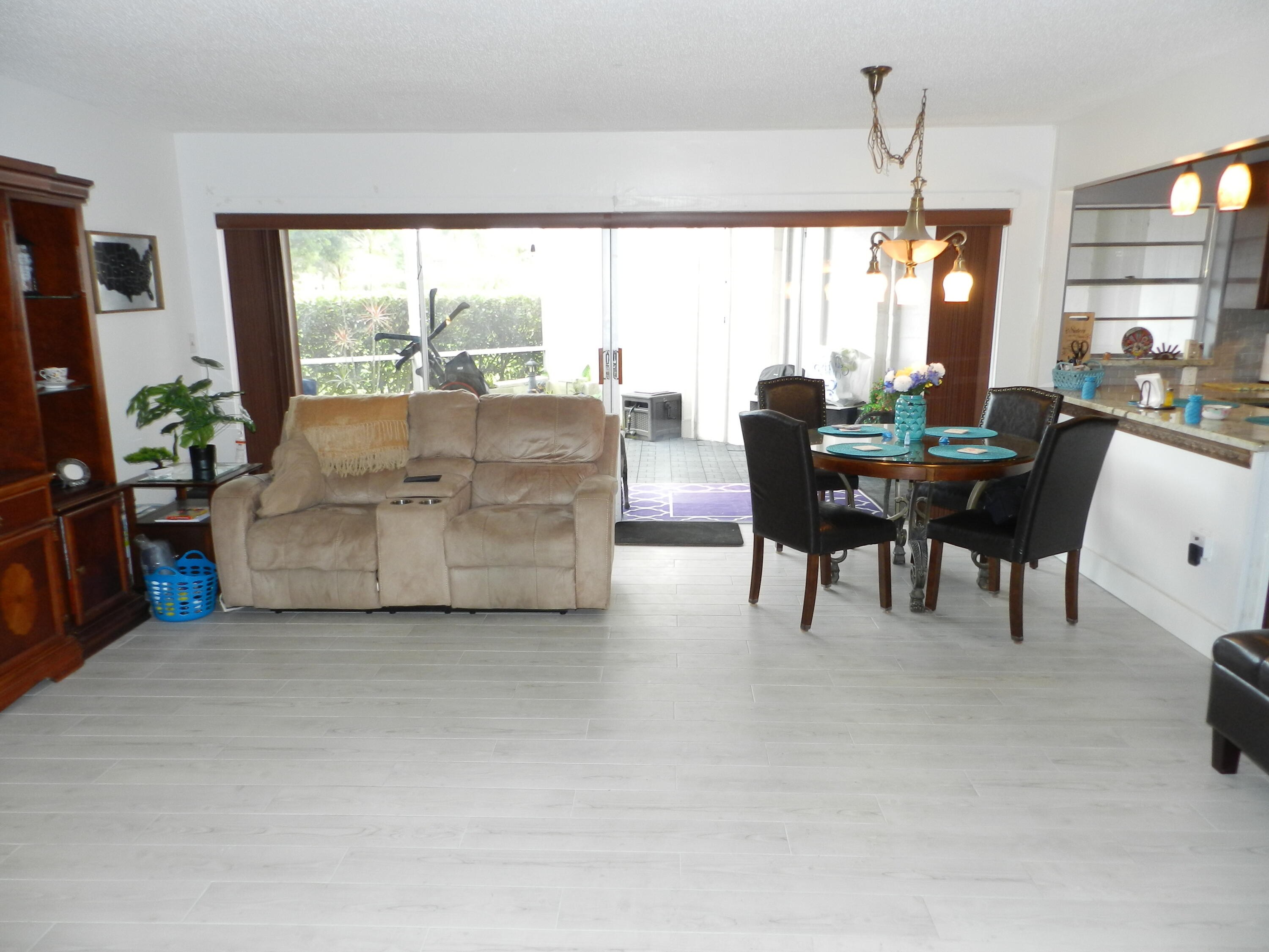 7 Greenway Village North, Unit 103 Royal Palm Beach, FL 33411 - Photo 8 of 29 a living room with couches a coffee table and a flat screen tv