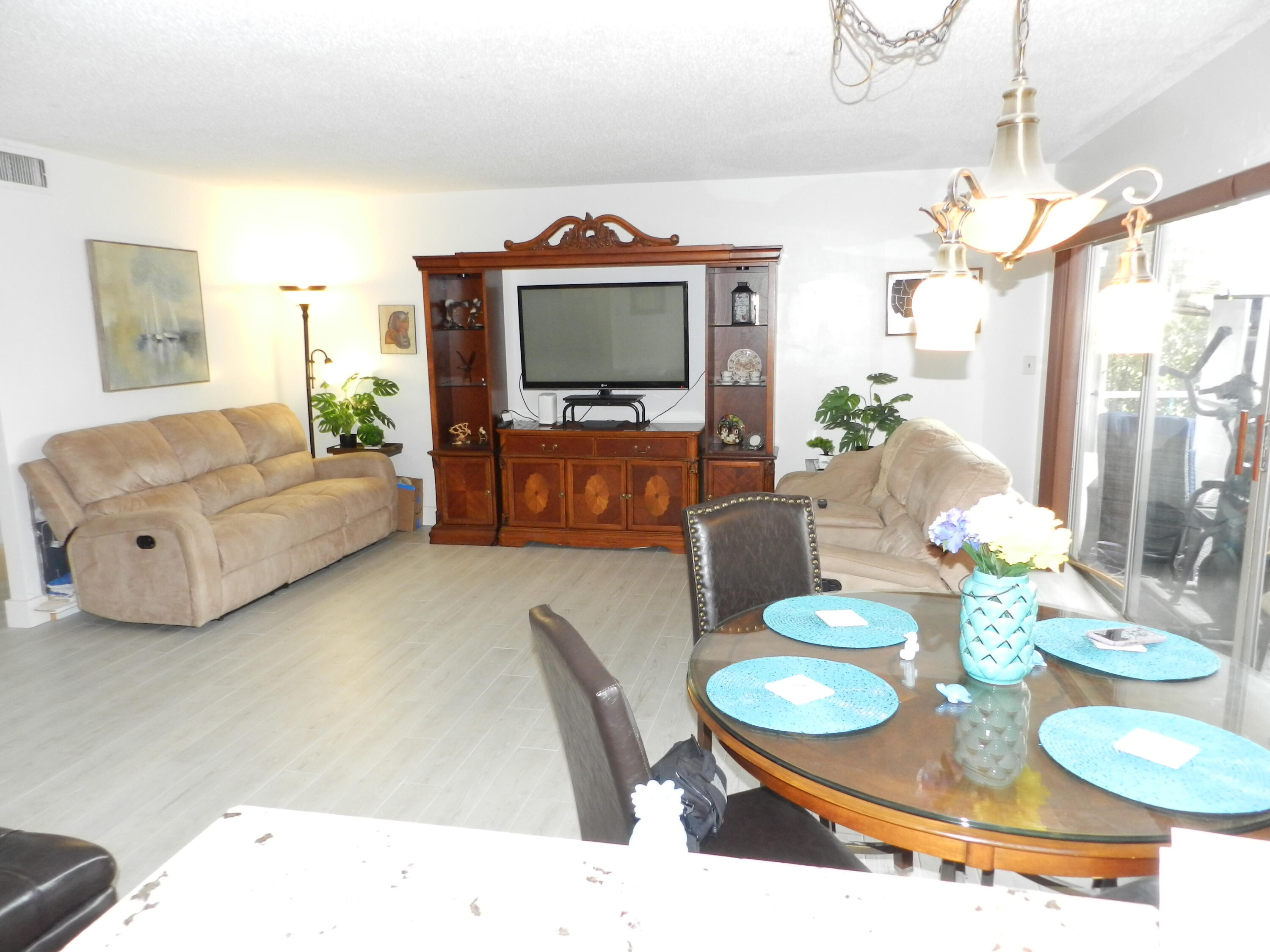 7 Greenway Village North, Unit 103 Royal Palm Beach, FL 33411 - Photo 9 of 29 a living room with furniture and a flat screen tv