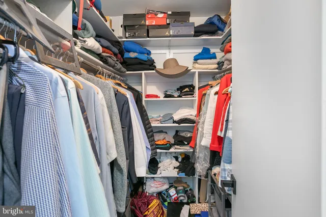 a view of walk in closet with clothes and shoes