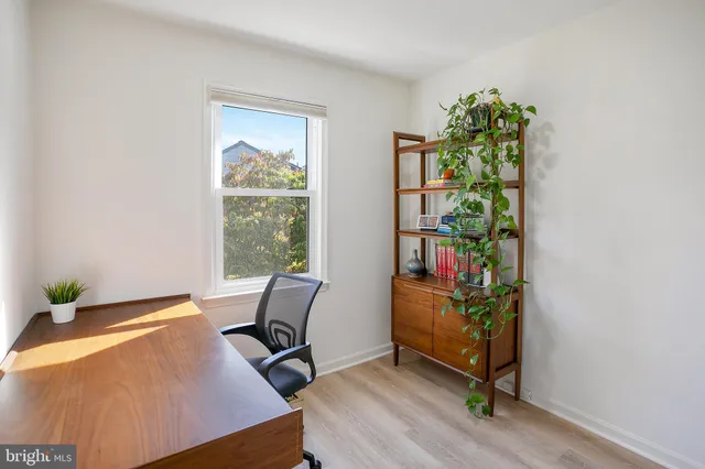 a view of a workspace with furniture and a window